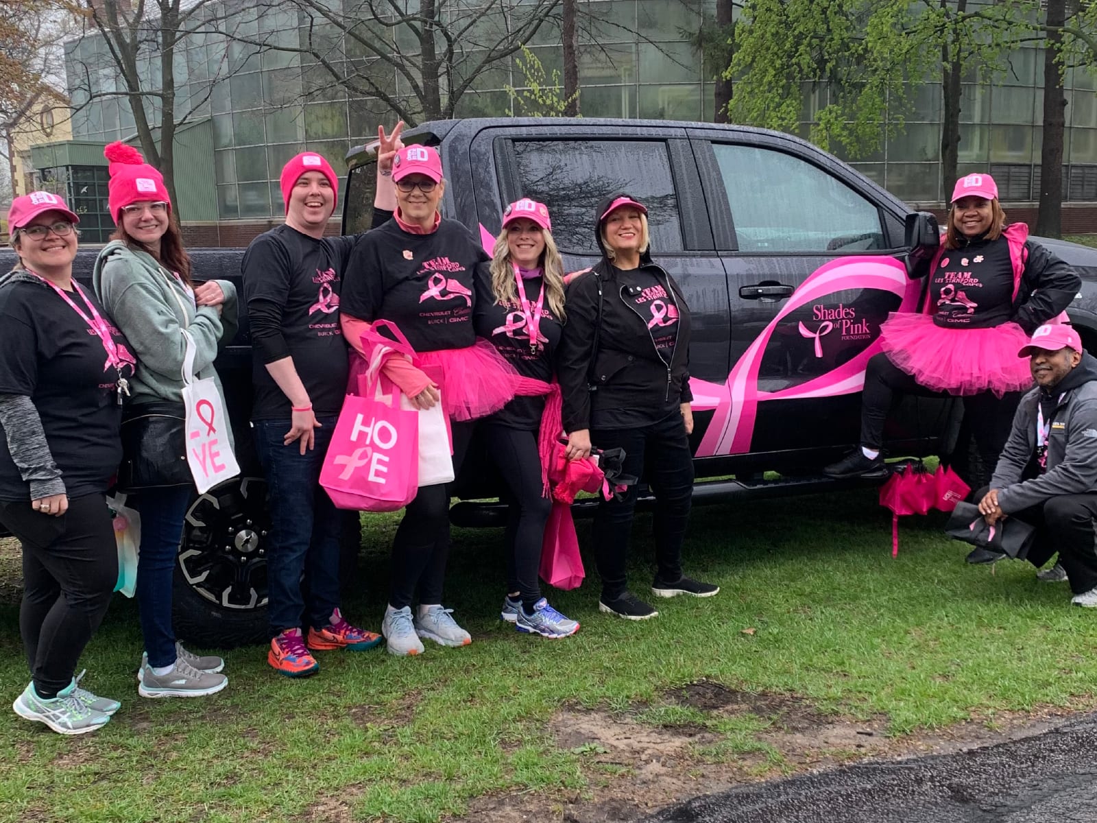 Team Les Stanford walkers in pink tutus and hats beside a Shades of Pink Foundation truck