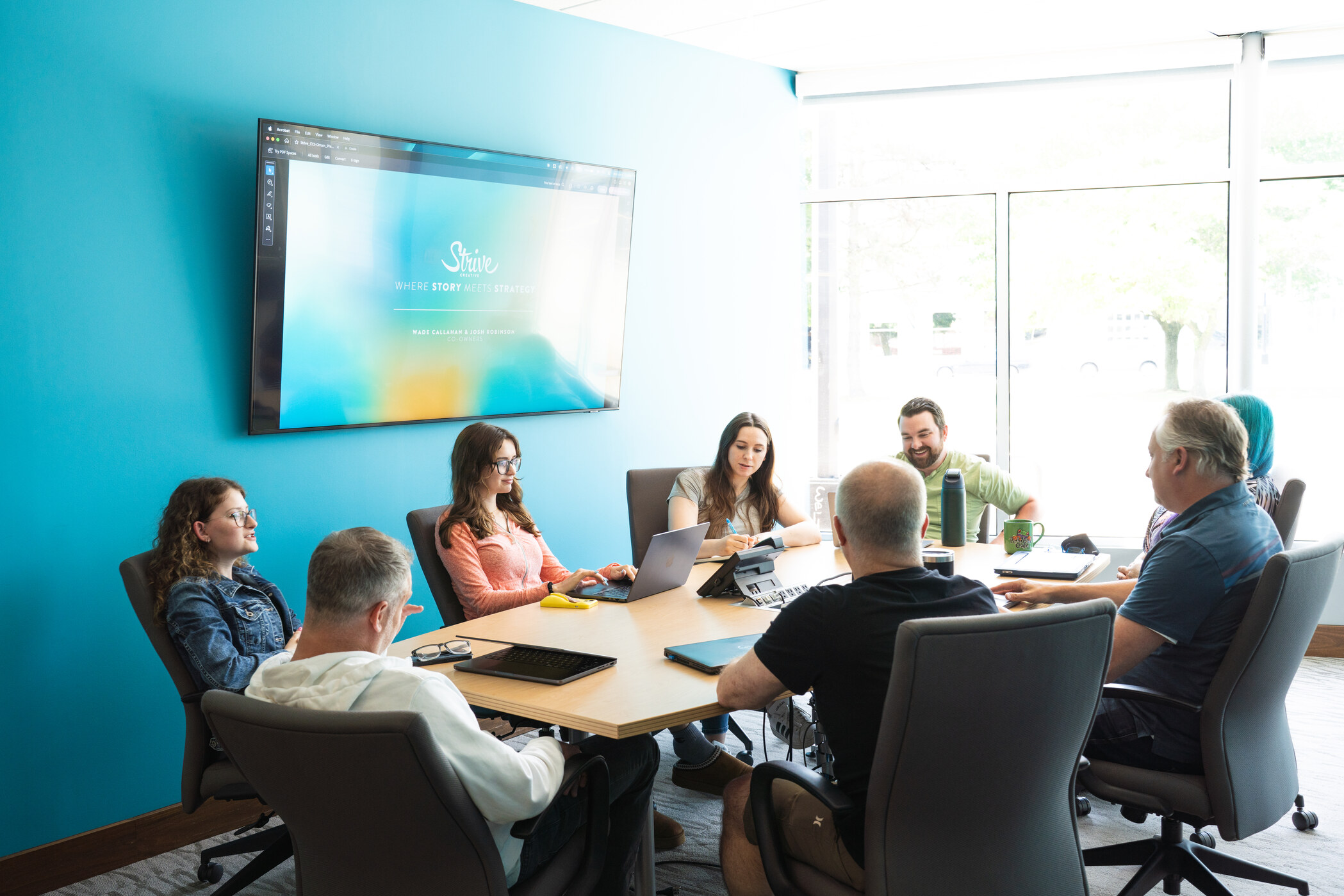 The Strive Creative team gathered around the conference table in active discussion