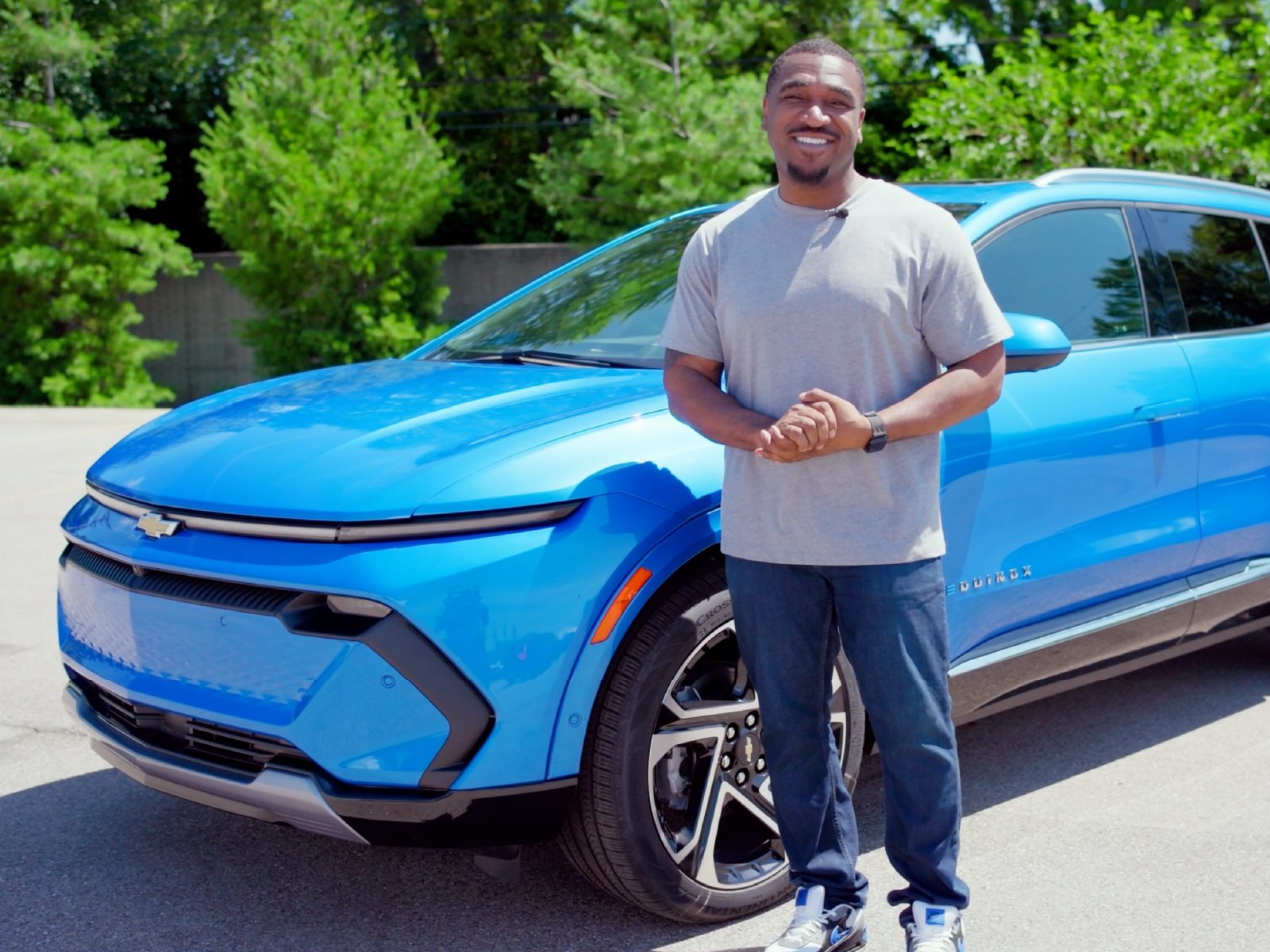 Presenter beside a blue Chevrolet Equinox EV