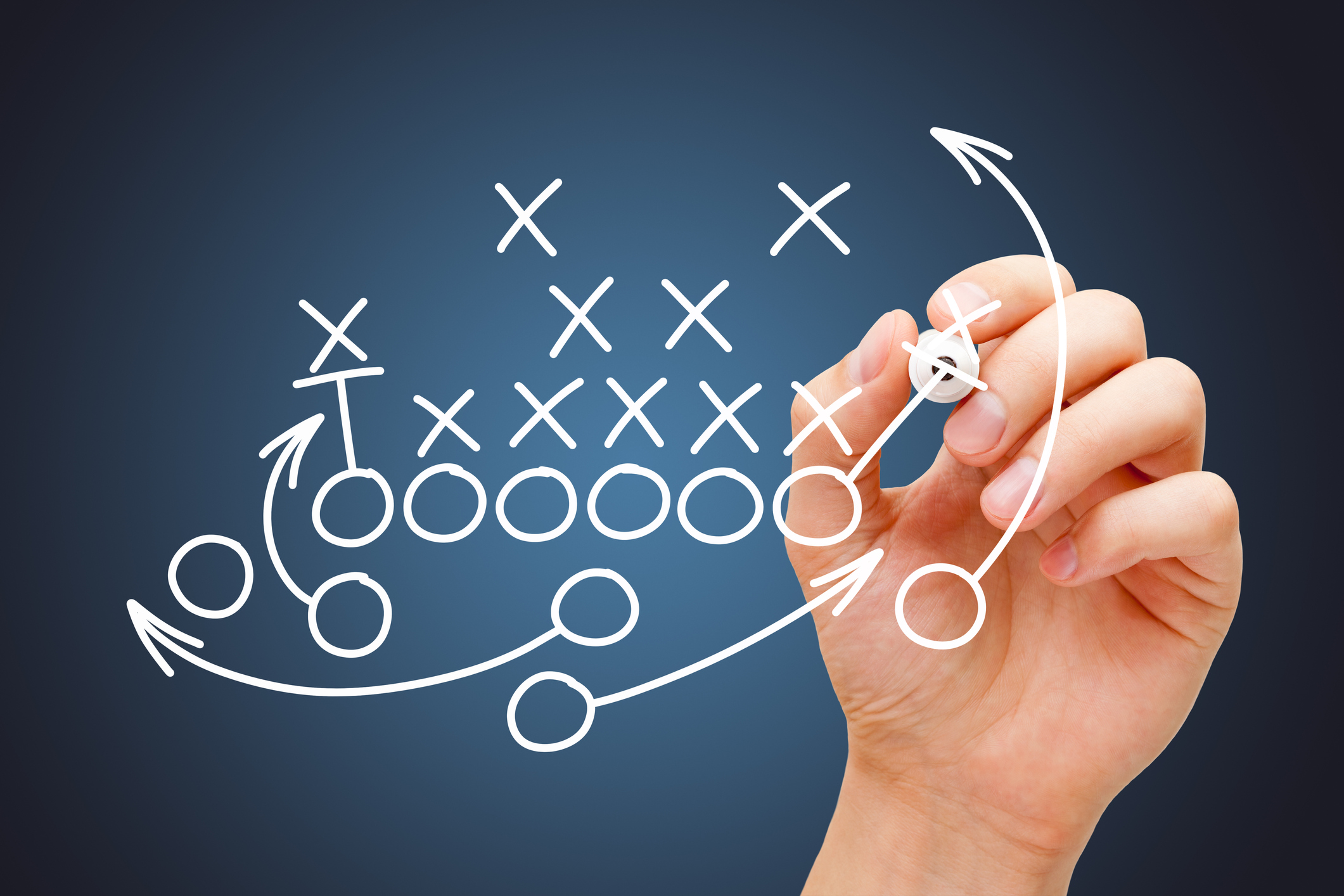 Coach drawing american football or rugby game playbook, strategy and tactics with white marker on blue background.