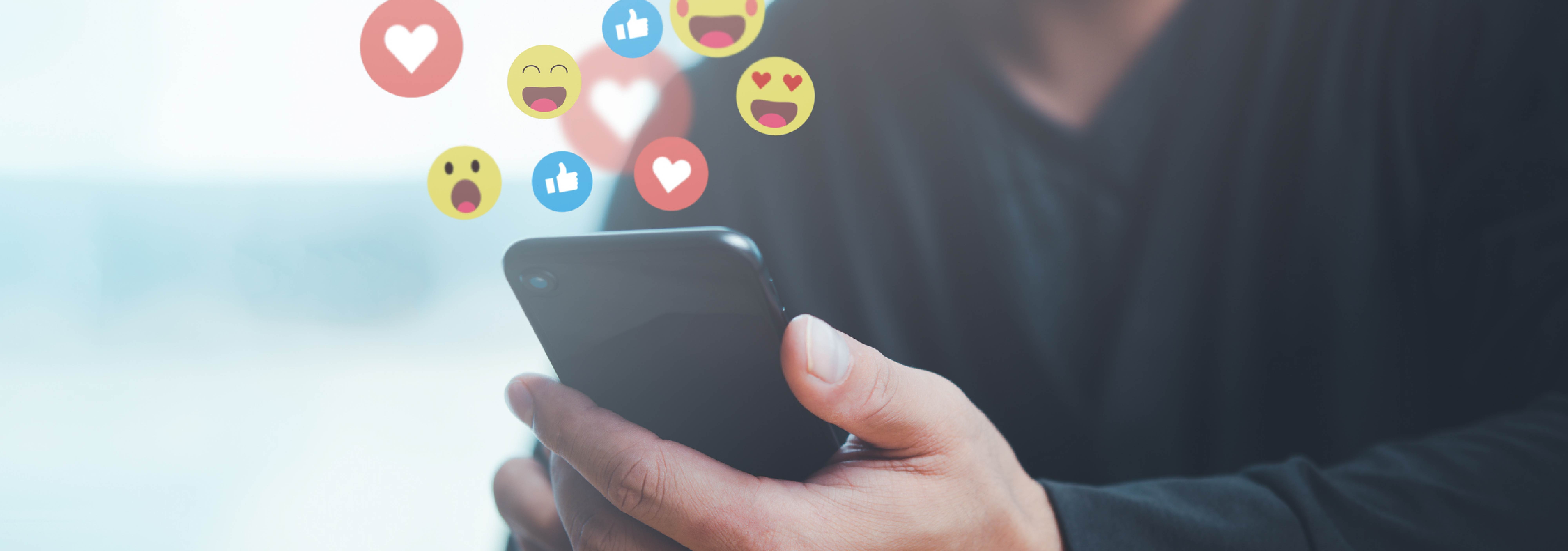 social media reactions floating above phone