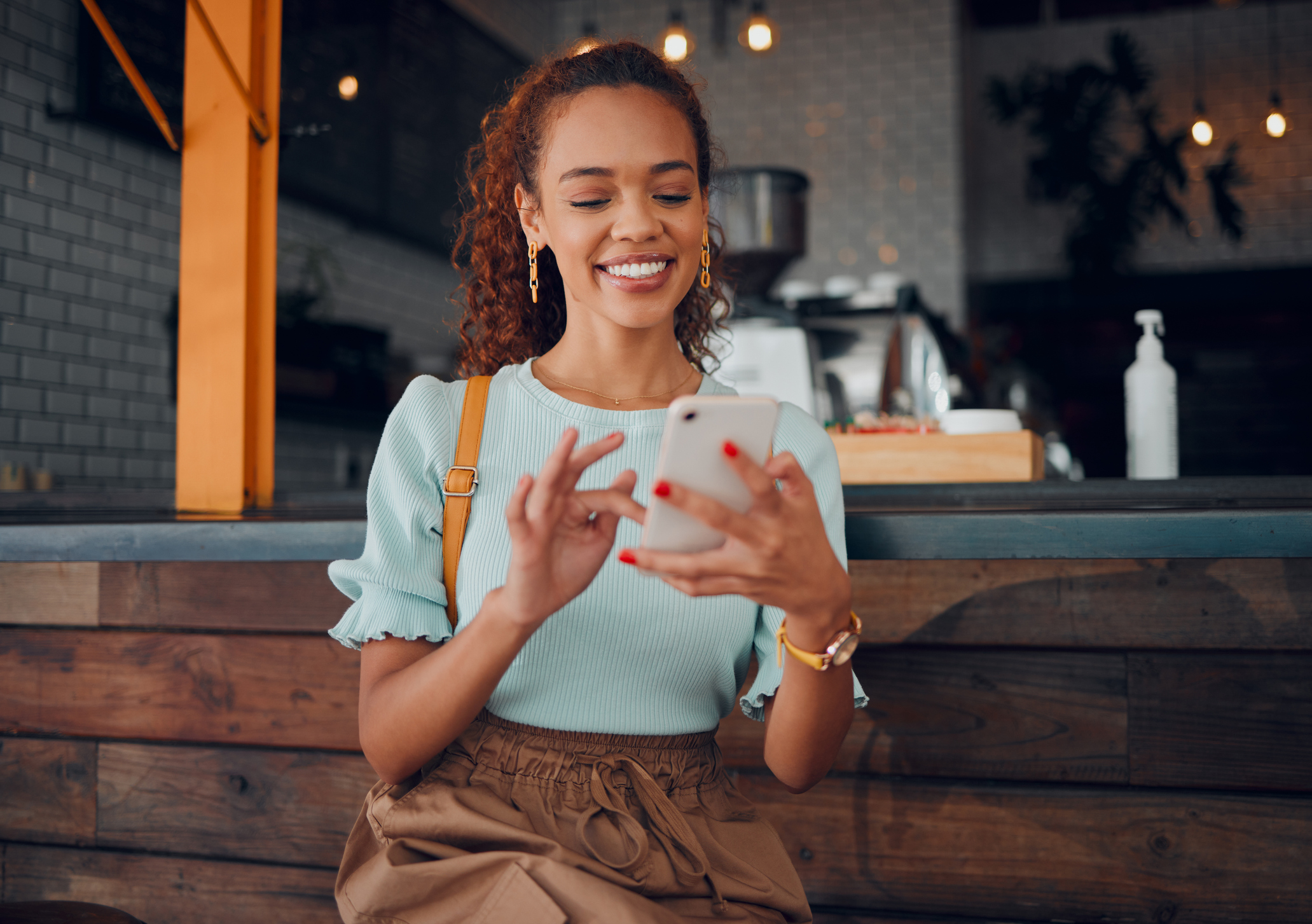 woman scrolling on her phone at a cafe